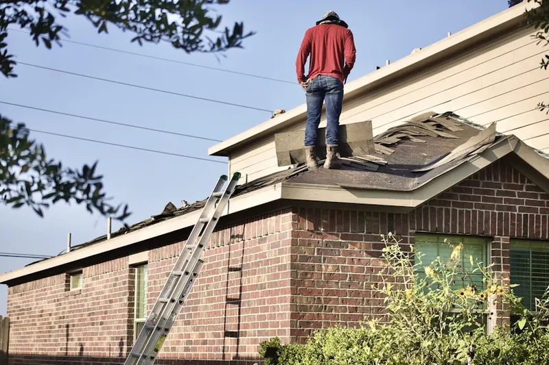 Professional roofer working on a residential roof in Riverwind